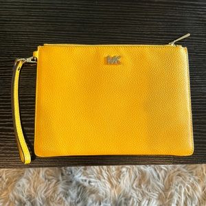 Michael Kors mustard yellow clutch bag wristlet with gold accent MK and zipper.